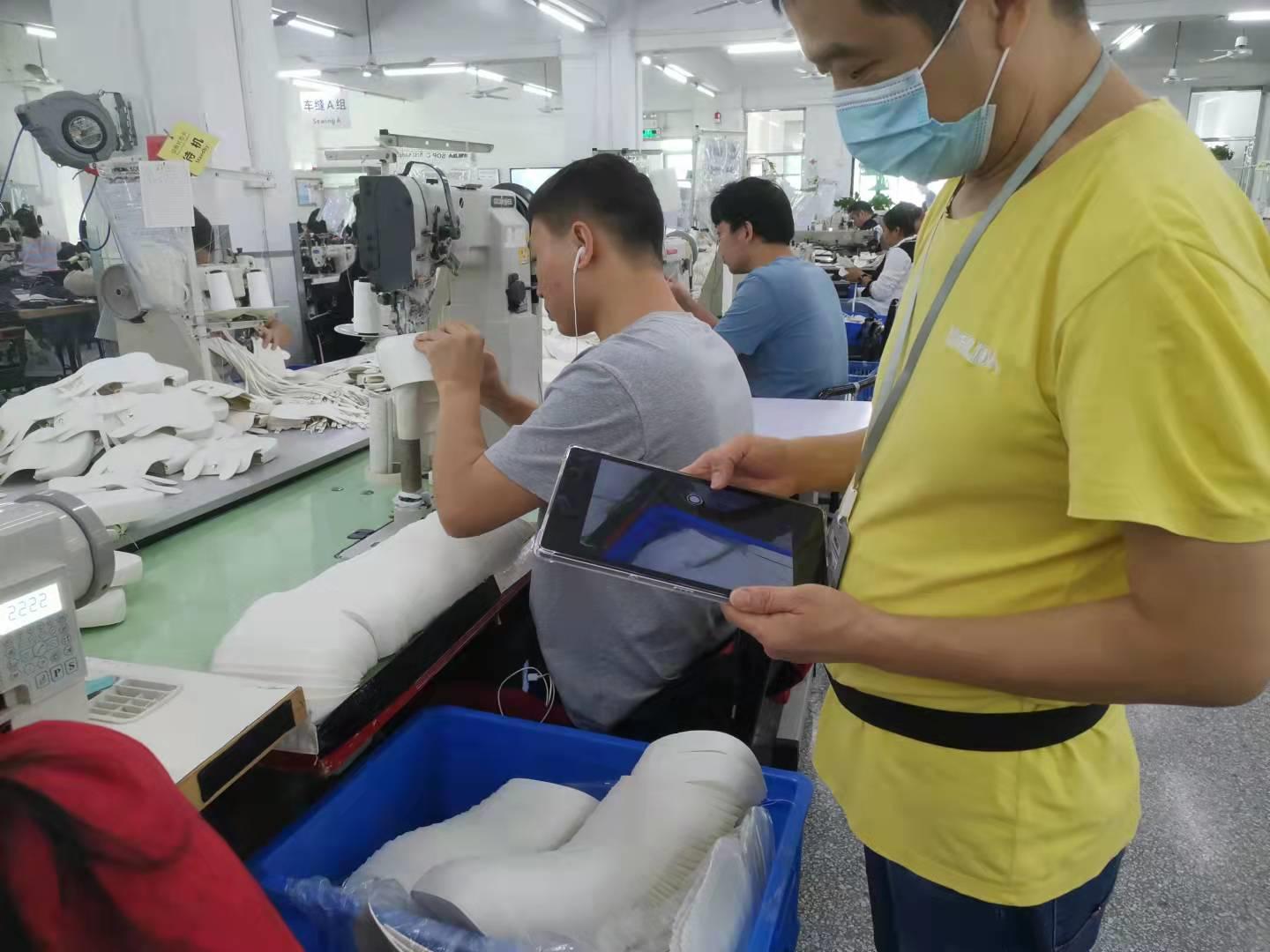 IPQC inspector using tablet for quality checks on production line