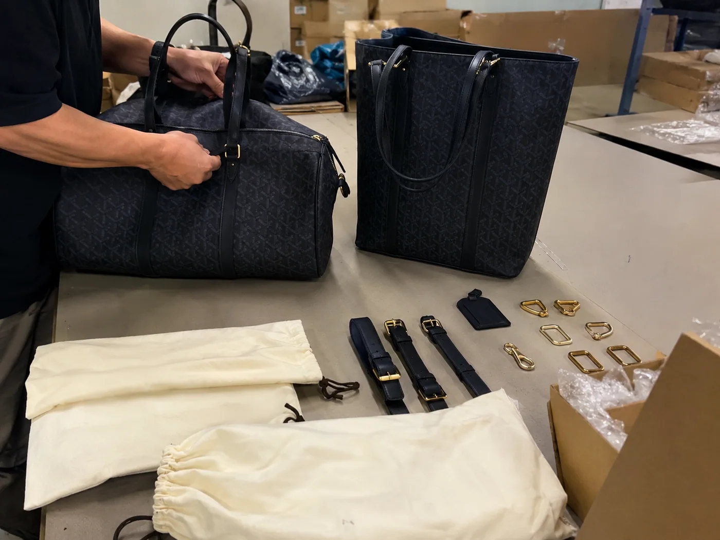 Smartphone-style premium gift bag and travel duffel samples checked with gold-tone hardware, dust bags, and carton corner