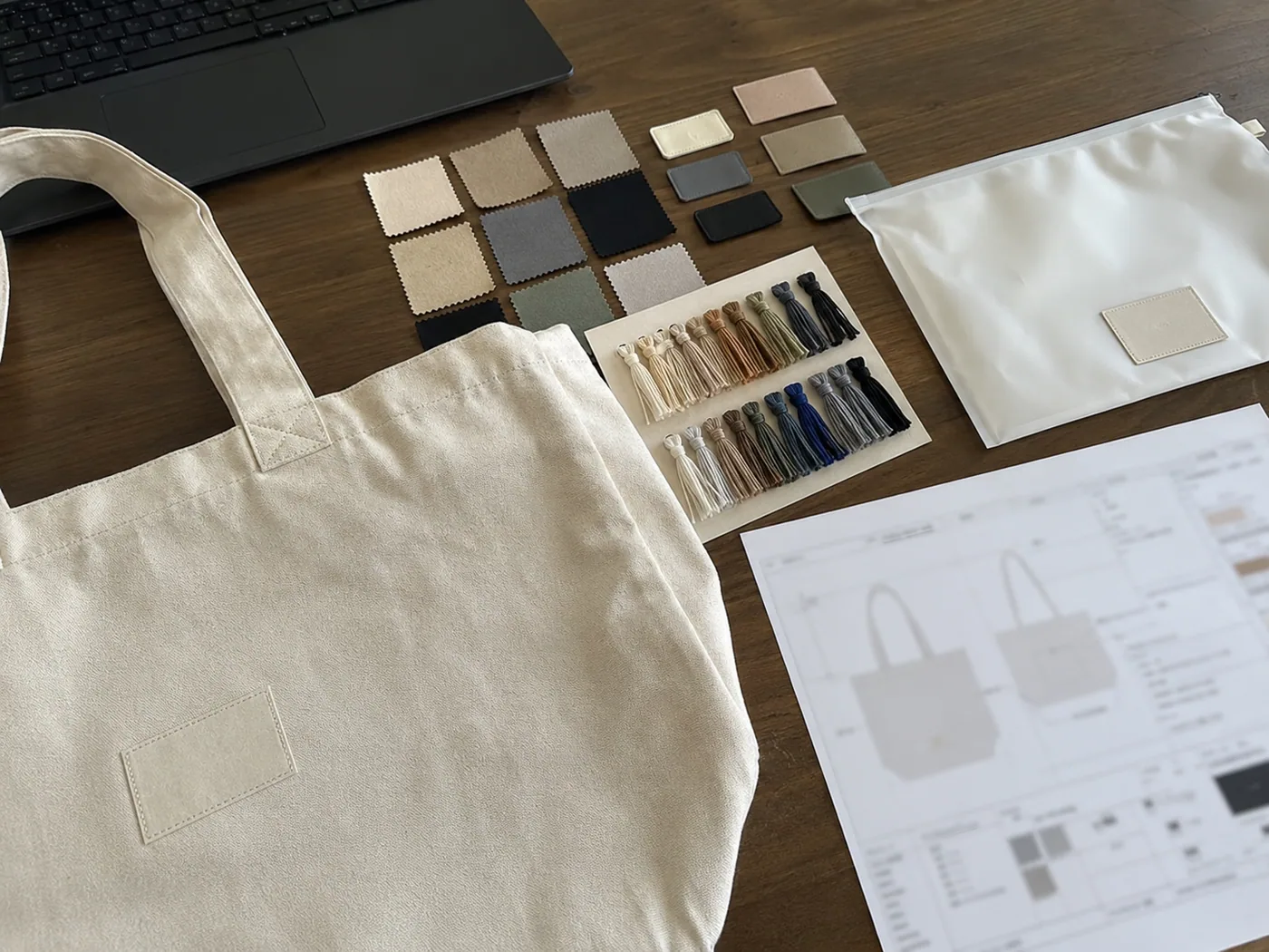 Smartphone-style private label RFQ kit with blank logo samples, embroidery swatches, tote prototype, packaging pouch, and blurred spec sheet